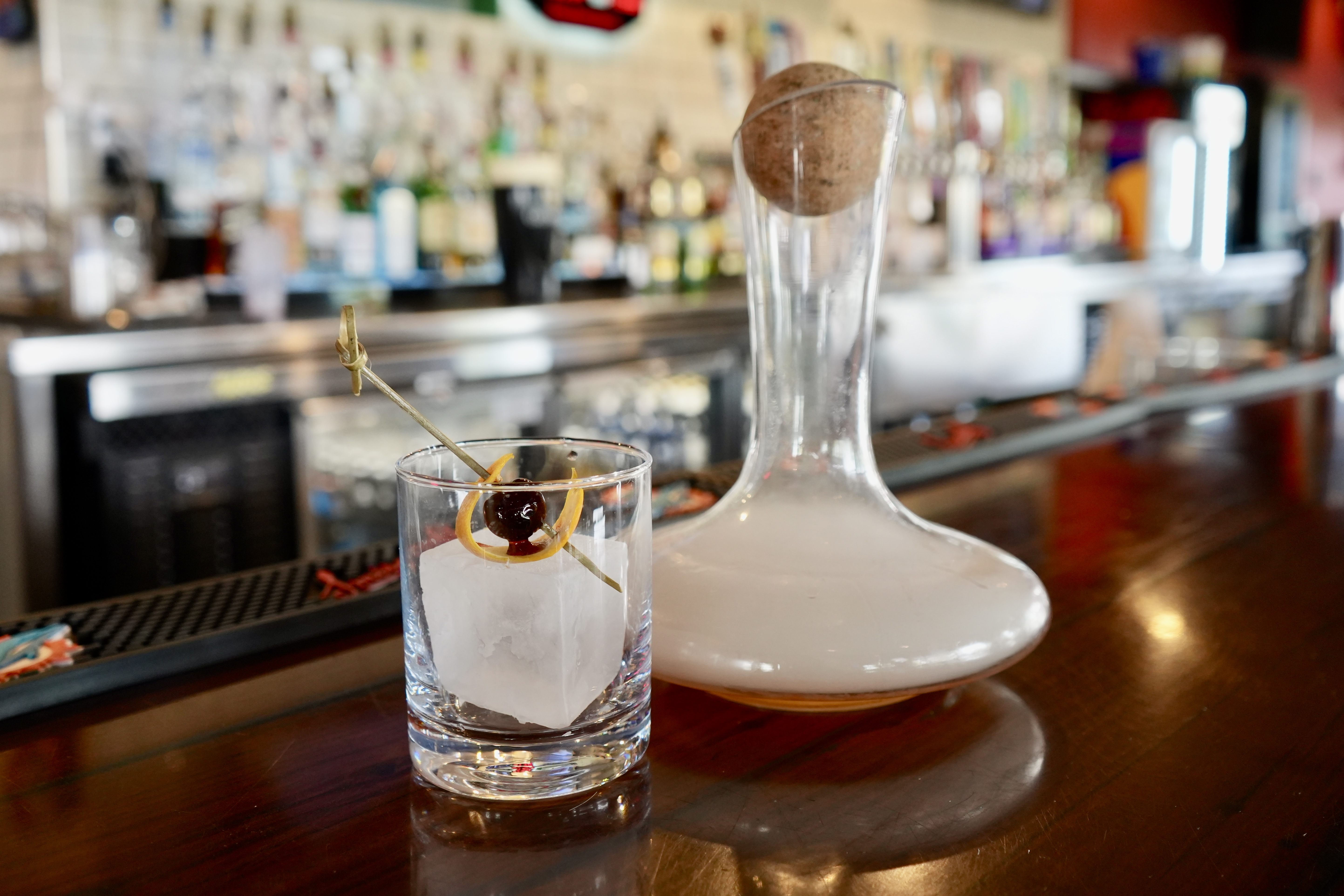 Old fashioned with a clear ice cube and decanter